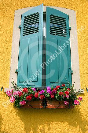 Shuttered window and flower box on a house in Kembs, France.