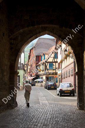 Street scene in Ribeauville, France framed in the arch of the town tower.