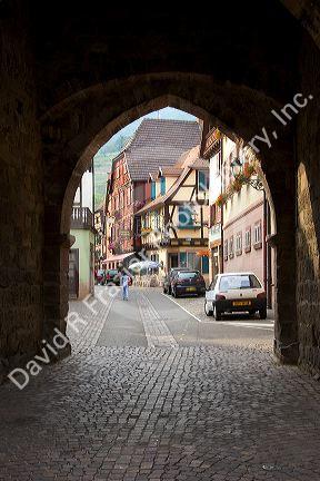 Street scene in Ribeauville, France framed in the arch of the town tower.