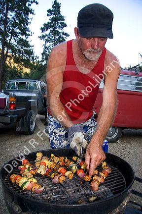 Campers preparing shish kabob meal.