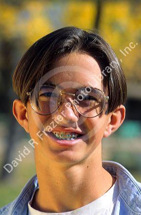 American teenage boy wearing eye glasses and braces on his teeth.