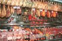 Hams hang in butcher shop in Madrid Spain.