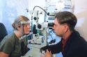 Optomitrist giving an eye exam.