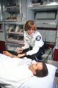Female paramedic with patient inside an ambulance.