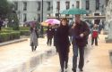 Pedestrians walking in the rain using umbrellas in Madrid, Spain.