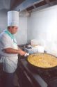 Spanish chef making paella,  rice and fish dish.