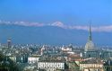 The Mole tower dominates the skyline of Turin, Italy with the Dolomite Mountains in the background.