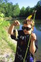 A young boy holding up the bluegill fish he caught.  MR