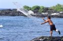 A Hawaiian man fishing with a net on BigIsland of Hawaii.