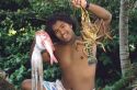 Hawaiian boy showing the fish, squid and lobster he caught.