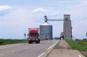 A grain elevator and storage bin and truck traveling on the highway in Mountain Lake, Minnesota.