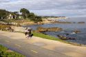 People jogging along the rocky shore in Monterey, California.