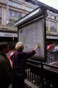 Tourists look at a city map in Paris, France.