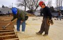 Construction workers install tongue and groove sub-floor in a new home.