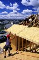Carpenters install roof sheathing during the construction of a new home.