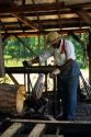 An african american man operates a sawmill at Agrirama Tifton, Georgia.