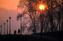 People walk along a path at sunset in Lucca, Italy.