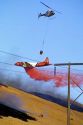 A  P-3 Orion fire bomber dropping retardant and a helicopter dropping water on a wildfire in Idaho.