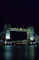 The Tower Bridge across the Thames River at night in London, England.