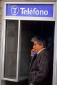 A man using a public telephone in Spain.