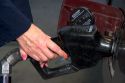 A woman's hands pumping gasoline into a car.
