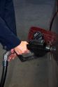 A womans hands pumping gasoline into a car.