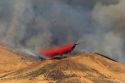 A C-130 airplane drops fire retardant on the Homestead Fire in the Boise foothills, Idaho.