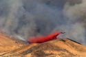 A C-130 Hercules airplane drops fire retardant on the Homestead Fire in the Boise foothills, Idaho.