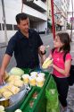 A young girl buying a corn snack from a street vendor in the Liberdade asian section of Sao Paulo, Brazil.