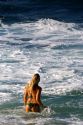 A woman wading in the pacific ocean off the island of Maui, Hawaii.