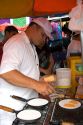 A man cooking tapioca into a kind of pancake in Manaus, Brazil.