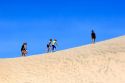 People walk on sand dunes at Pacific City on the Oregon Coast.
