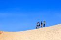 People stand on sand dunes at Pacific City on the Oregon Coast.