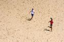 People running on sand dunes at Pacific City on the Oregon Coast.