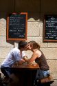Young couple kissing at a sidewalk cafe in Saint-Malo in Brittany, northwestern France.