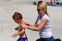 Mother applying sunscreen to her son on the beach at St. Petersburg, Florida. MR