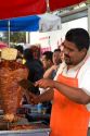 Street vendor cooking and cutting meat for soulvaki in Mexico City, Mexico.