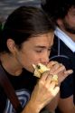 Woman eating a chorizo sandwich along the Rio de la Plata in Buenos Aires, Argentina.