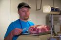 Butcher weighing a pork roast at a butcher shop in Boise, Idaho. MR