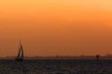 Sailboat and sunset at Fort Myers Beach on Estero Island in Lee County, Florida.