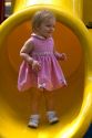 15 month old girl standing at the end of a slide in Tampa, Florida. MR