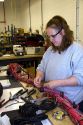 Female worker with wiring harness assembly at Spartan Motors truck chassis manufacturing in Charlotte, Michigan.