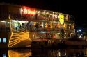 Floating restaurants on the Saigon River with lights at night in Ho Chi Minh City, Vietnam.