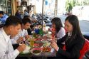 Vietnamese office workers eat lunch at a sidewalk cafe in Ho Chi Minh City, Vietnam.