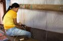 Vietnamese woman manufacturing woven rugs at a craft center in Hoi An, Vietnam.
