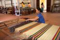 Vietnamese woman manufacturing woven rugs at a craft center in Hoi An, Vietnam.