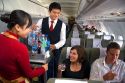 Flight attendents serve beverages to passengers on a Vietnamese airliner.