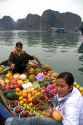Vietnamese boat vendors selling fruit in Ha Long Bay, Vietnam.