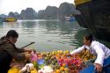 Vietnamese boat vendors selling fruit in Ha Long Bay, Vietnam.