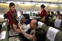 Vietnamese flight attendants serve food and drink to passengers on a Boeing airliner in Vietnam.